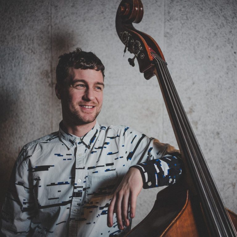 Relaxed Bassplayer with upright bass and hip shirt