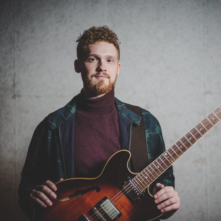 Guitarist Moritz Land with red curly Hair and beard