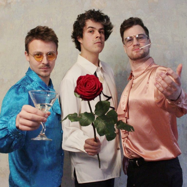 Three musicians: first one holding champange second holding rose, third smokig cigarette (Nicolas Greiner, Johannes Bode, Lukas Growe)
